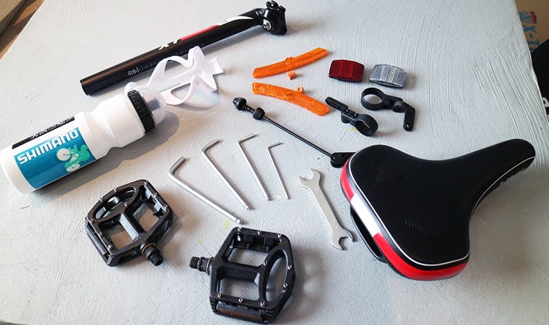 polkupyörän pumppu, satula, polkimet, heijastimet ja työkalut pöydällä